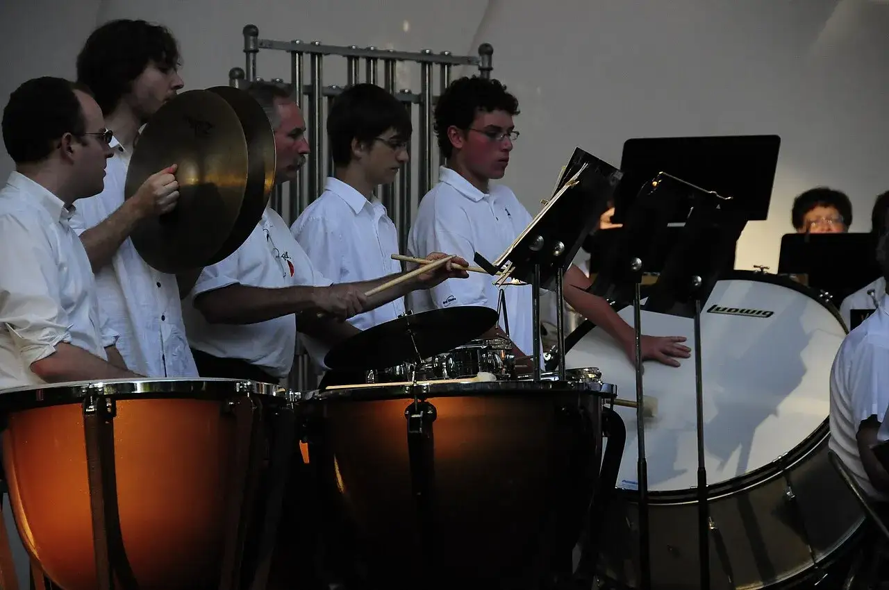 Orkiestra gra na instrumentach perkusyjnych: kotłach, talerzach i bębnach.