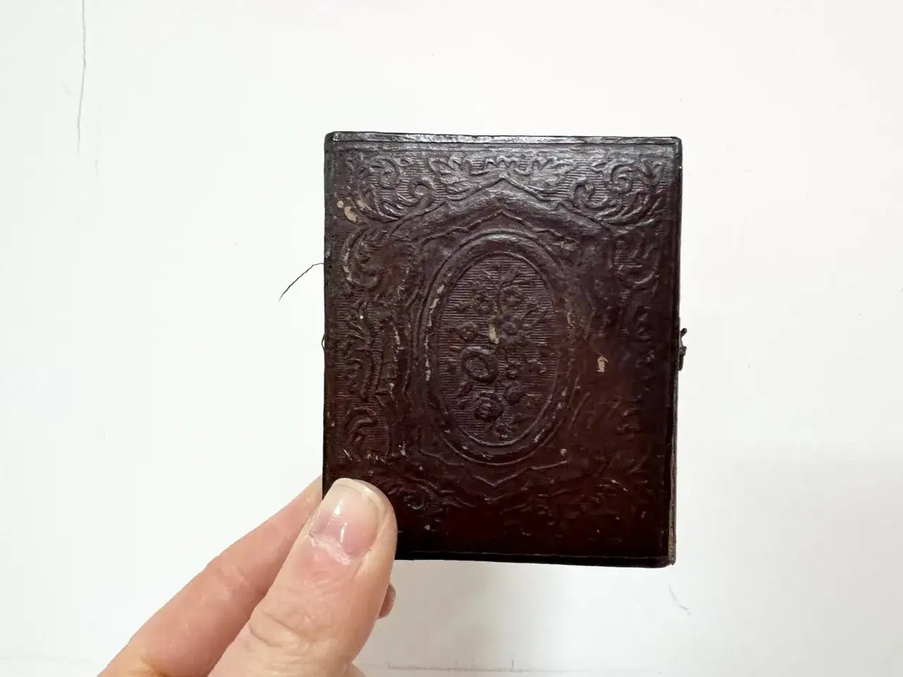 Custodia scura con rilievi floreali, tipica per un dagherrotipo. Cos'è un dagherrotipo? Un'antica tecnica fotografica.