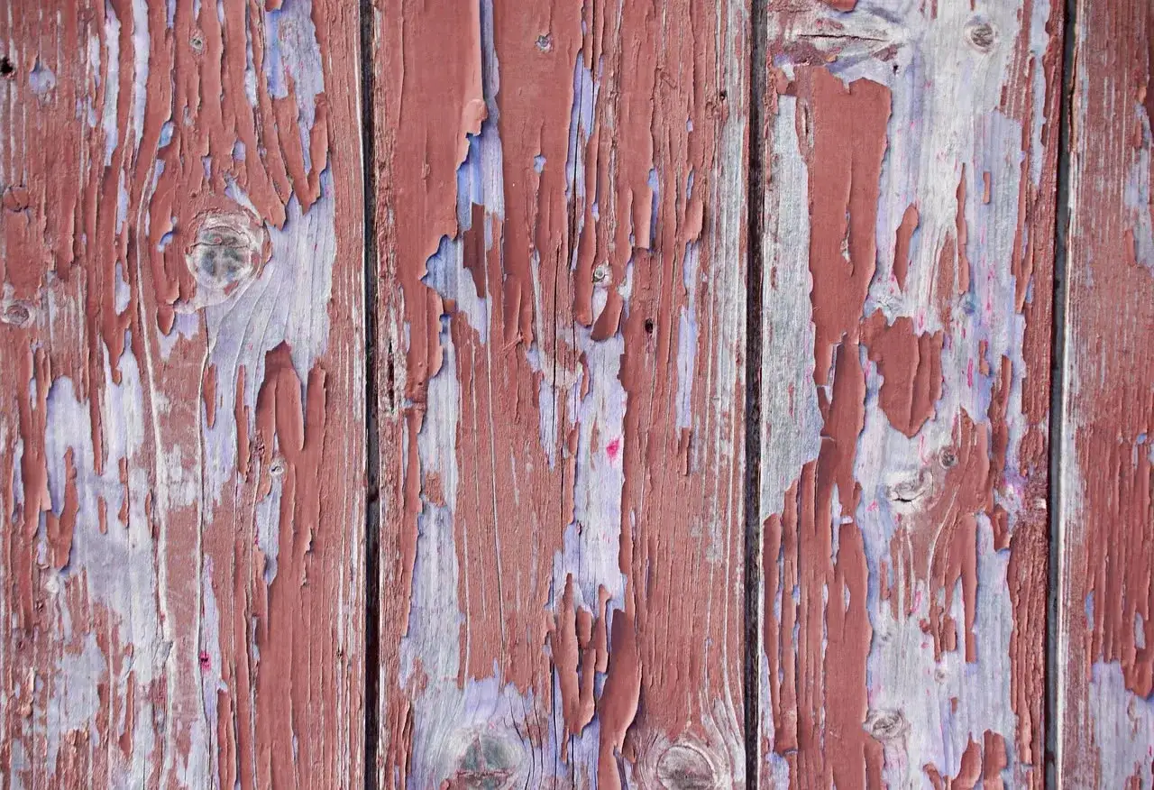 Legno con vernice scrostata, effetto **tecnica shabby a due colori** rosso e viola.