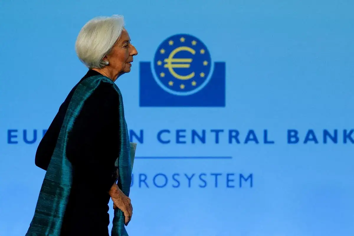 Christine Lagarde, prezes EBC, idzie na tle logo banku. Jej kadencja trwa 8 lat.