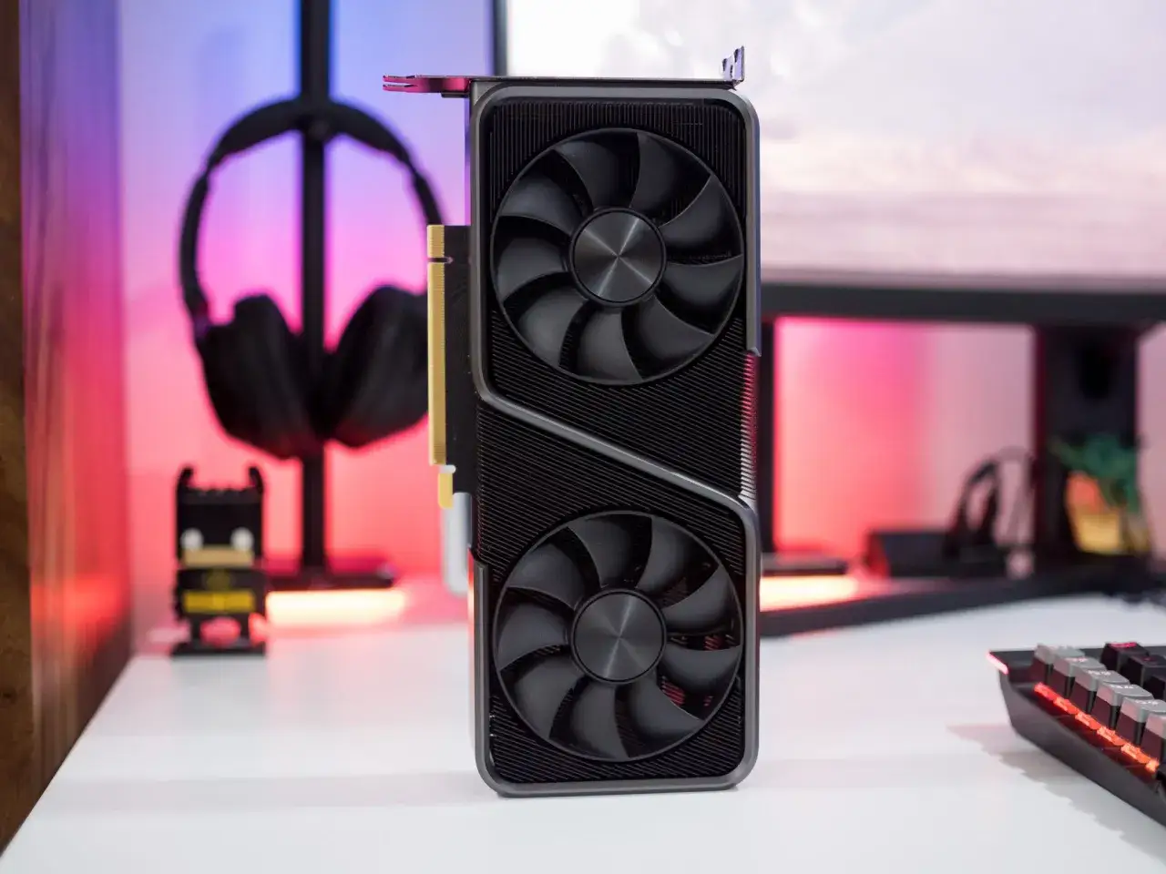 Grafikkarte im Fokus, bereit für den Vergleich 3060 ti vs 3070. Im Hintergrund Kopfhörer und ein kleiner Batman.