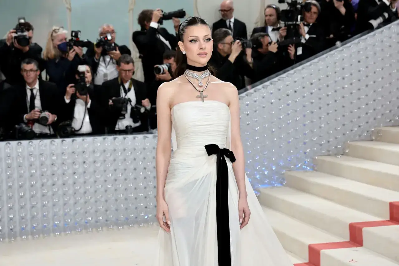 Nicola Peltz, deslumbrante con un vestido blanco y negro, posa ante una multitud de fot&oacute;grafos.