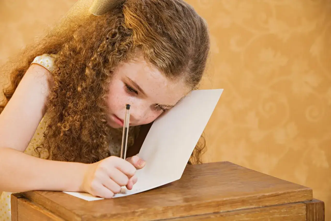 Dziewczynka z burzą rudych loków pochyla się nad kartką, pisząc. Czasem litery tańczą, jakby to był świat, jak widzi dyslektyk.