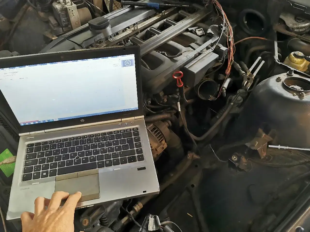 Diagnostyka komputerowa silnika, kt&oacute;ry ma problem z dławieniem przy przyspieszaniu. Laptop podłączony do ECU.