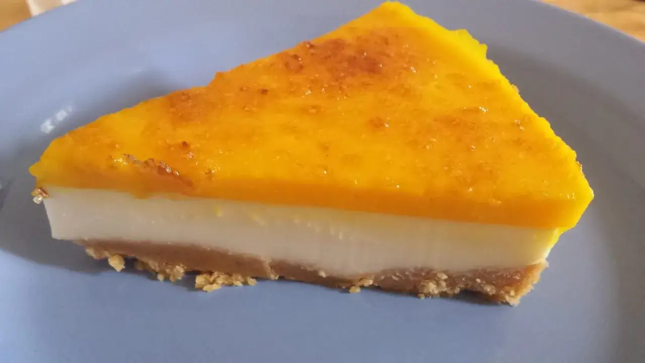 Rebanada de tarta de queso La Viña, con base crujiente, relleno cremoso y cubierta dorada. ¡Una receta auténtica irresistible!