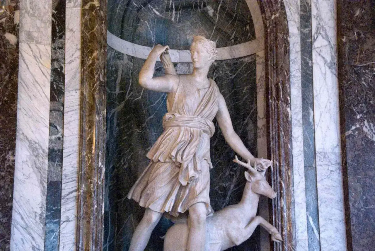 Kamienna rzeźba przedstawia Artemidę boginię, z łukiem i jelonkiem.