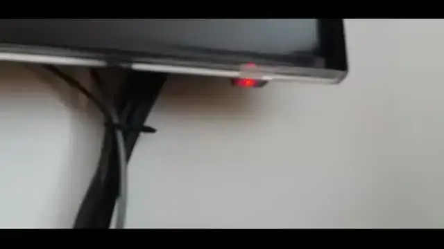 czerwona dioda standby na telewizorze w ciemnym pokoju
