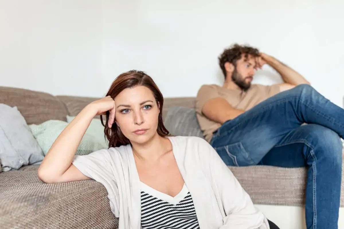 Coppia seduta sul divano, distanti e pensierosi. Quanto può durare una crisi di coppia?