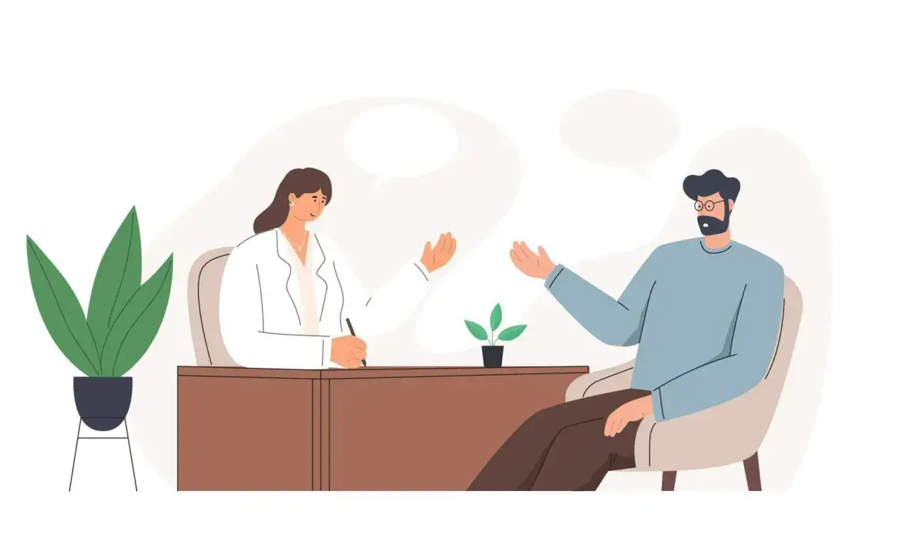 Un uomo parla con una psicoterapeuta che ascolta e prende appunti. Si percepisce che lo psicoterapeuta aiuta davvero, offrendo uno spazio sicuro per esprimersi.