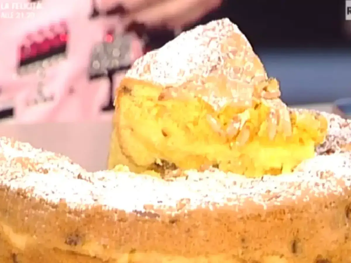 Un delizioso danubio dolce, soffice e cosparso di zucchero a velo, con una fetta che rivela un ripieno cremoso e pinoli croccanti.