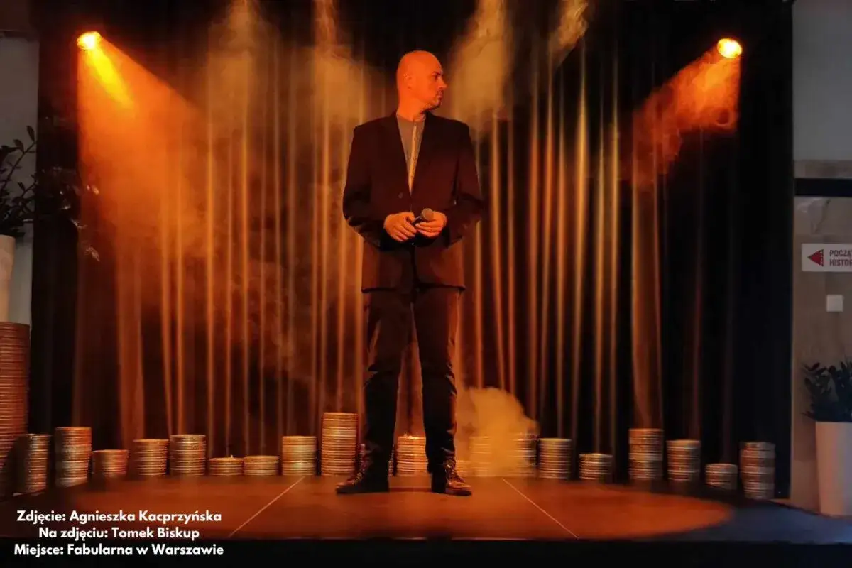 Tomek Biskup na scenie w Warszawie, gotowy do polskiego stand-upu.