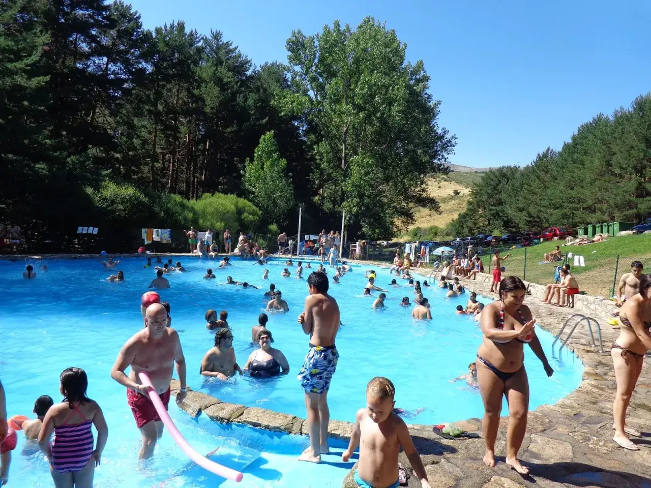 Gente disfrutando de un día soleado en la piscina de la panera Segovia.