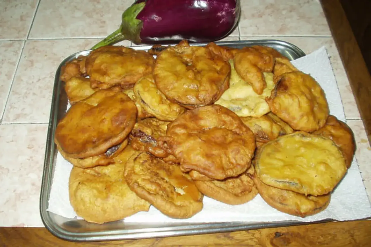 Un plateau rempli de beignets d'aubergine dor&eacute;s et croustillants, pr&ecirc;ts &agrave; &ecirc;tre d&eacute;gust&eacute;s.