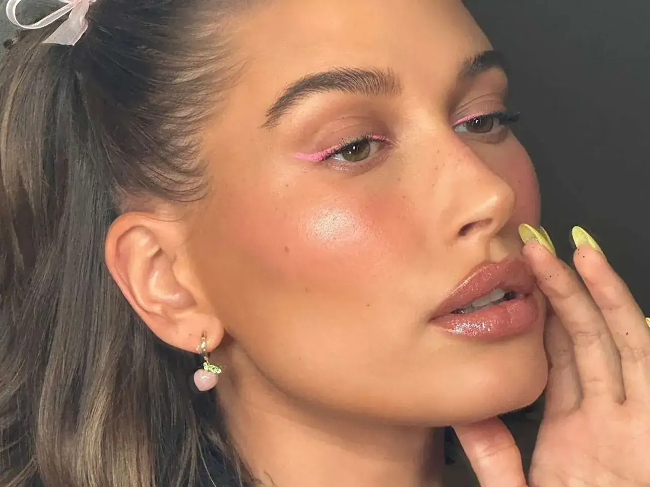 En kvinna med rosa eyeliner och glansiga l&auml;ppar. Hennes kindben framh&auml;vs med en subtil contour guide.