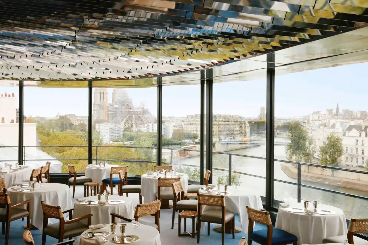 Tables dressées pour un dîner romantique à Paris, avec vue sur la Seine et Notre-Dame.