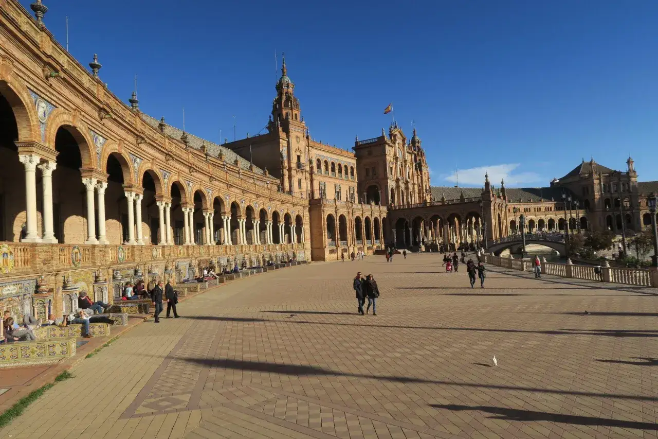 Sonnige Plaza de Espa&ntilde;a in Sevilla, ideal f&uuml;r einen Ausflug mit Kindern. Bunte Kacheln und Arkaden laden zum Entdecken ein.