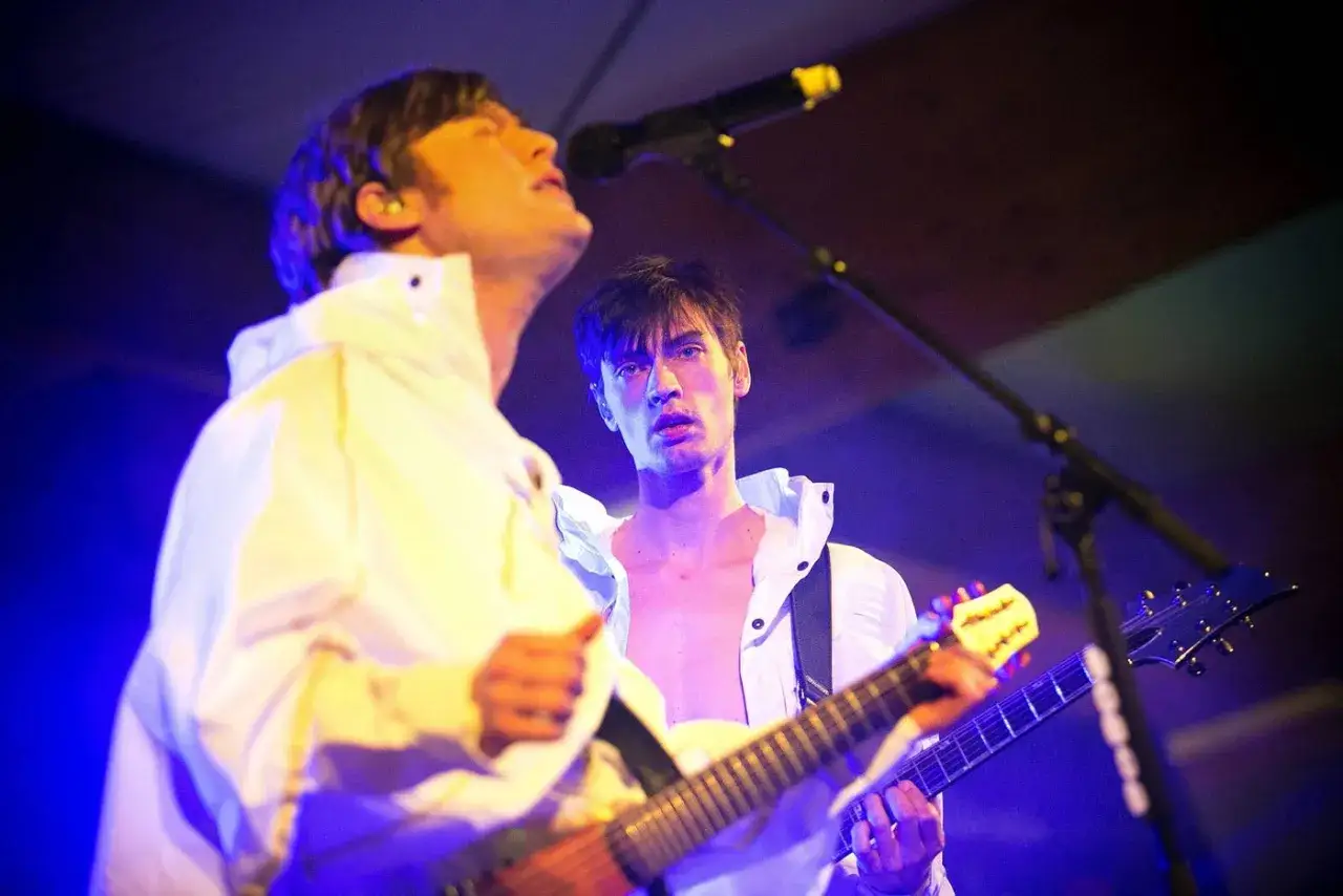 Gustaf Norén och Mando Diao på scen, upplysta av blått och gult ljus.