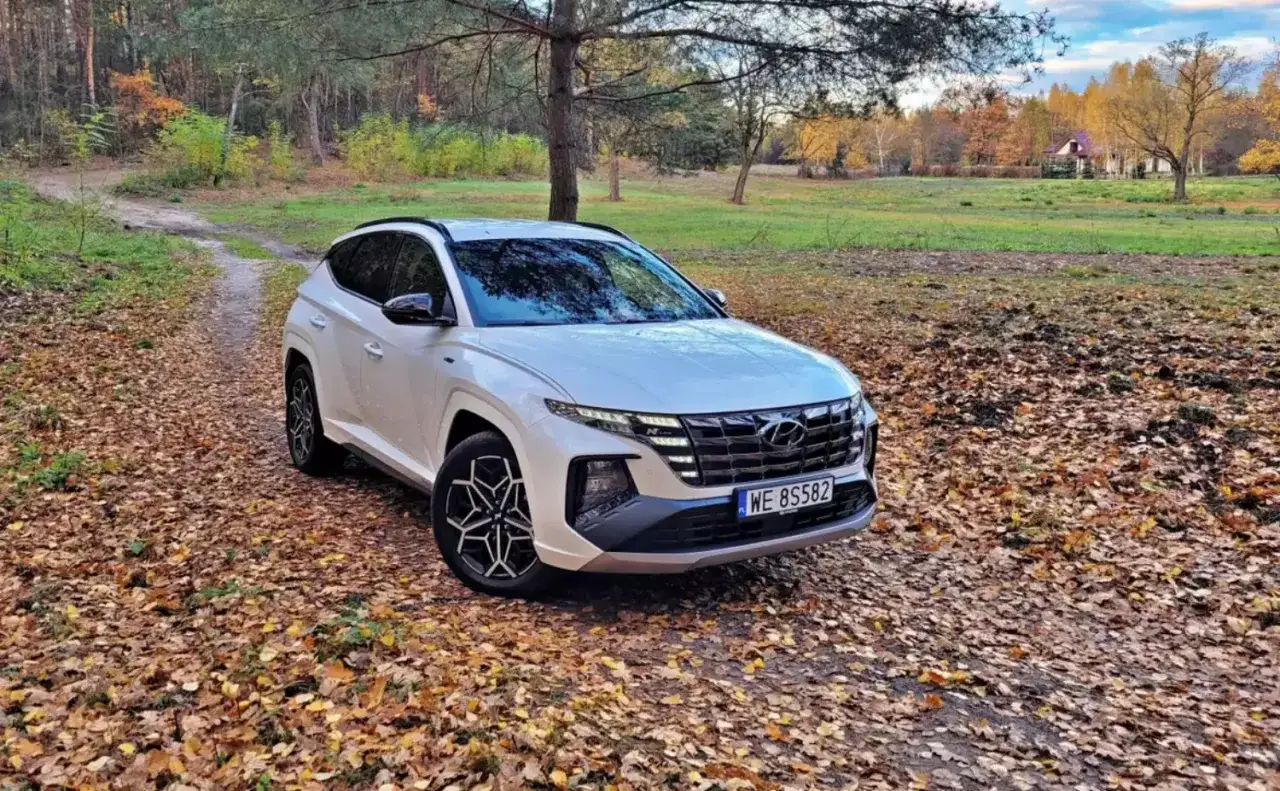 Biały SUV Hyundai Tucson na tle jesiennego lasu. Idealny wybór dla firm ceniących leasing operacyjny i komfort podróży.