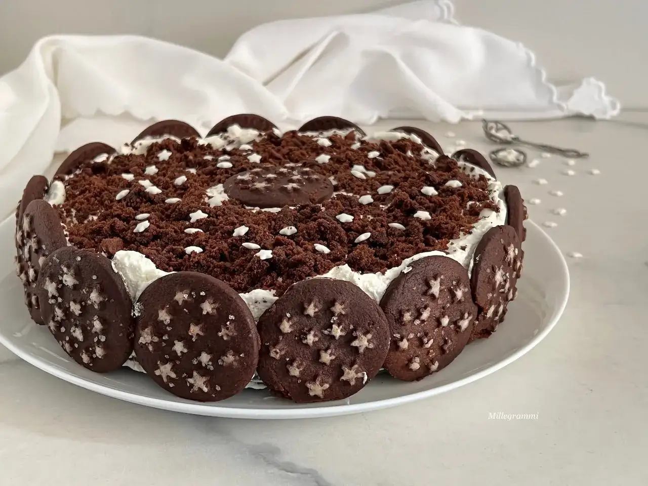 Torta Pan di Stelle decorata con biscotti e cacao, un dolce che fa sognare.