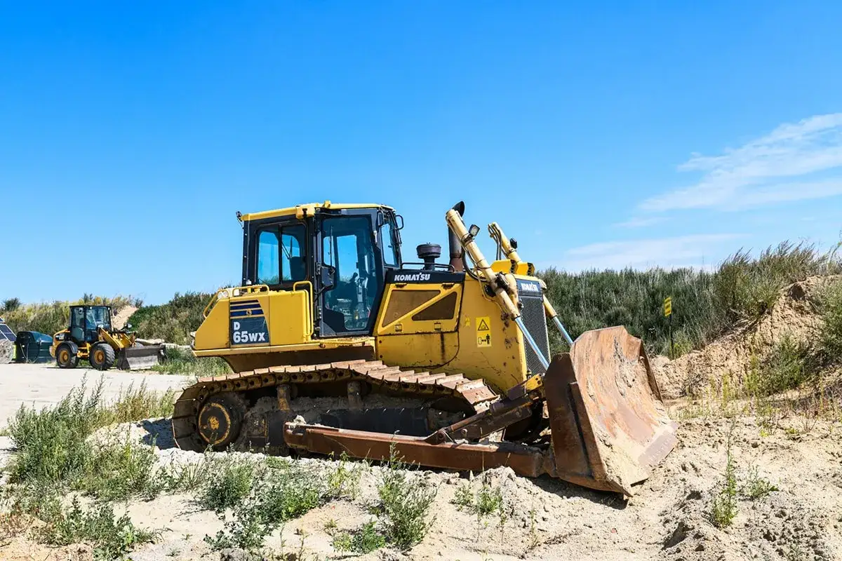 Żółta spycharka Komatsu D65WX gotowa do pracy. Idealne miejsce na kurs na spycharki.