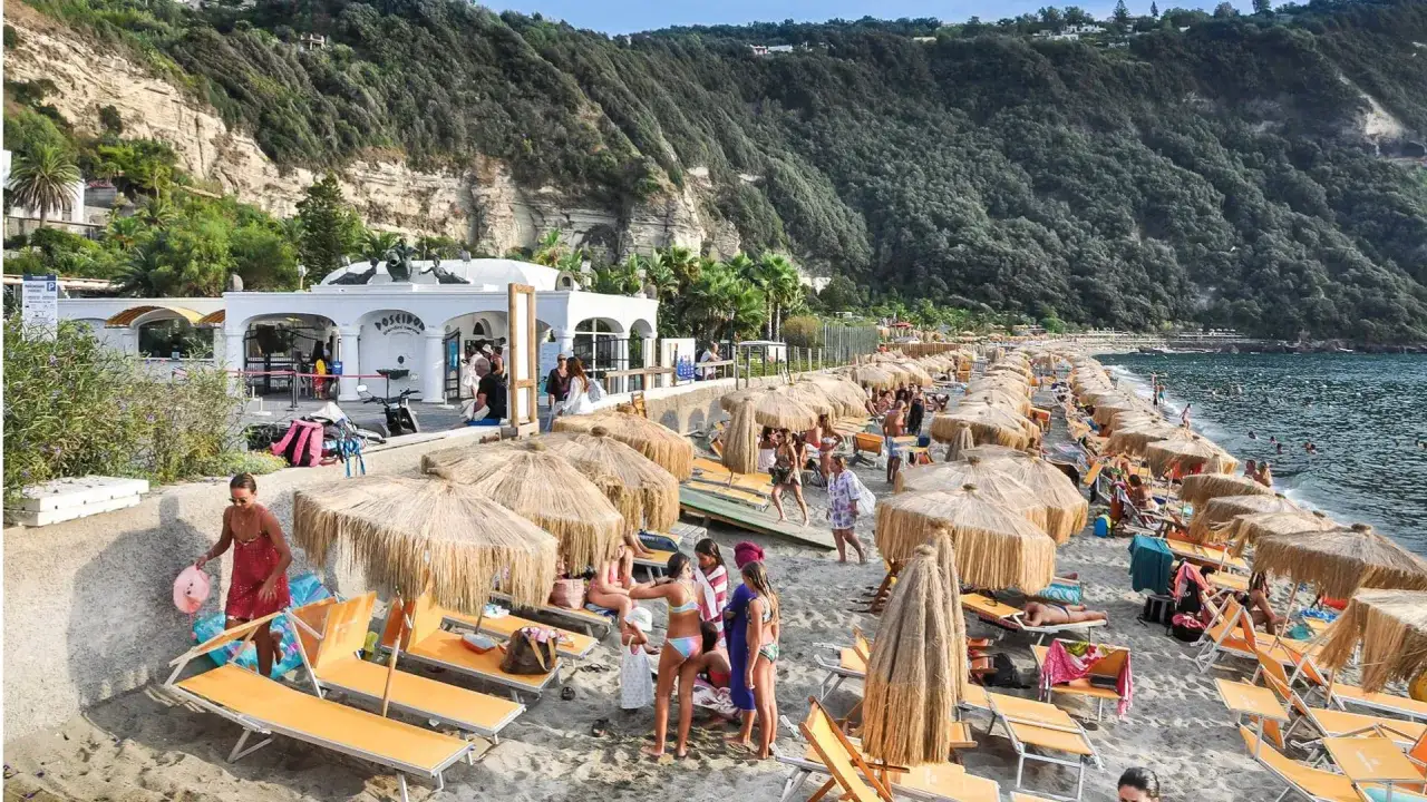 Spiaggia di Citara affollata con ombrelloni e lettini. Per arrivare, segui le indicazioni per Forio d'Ischia.