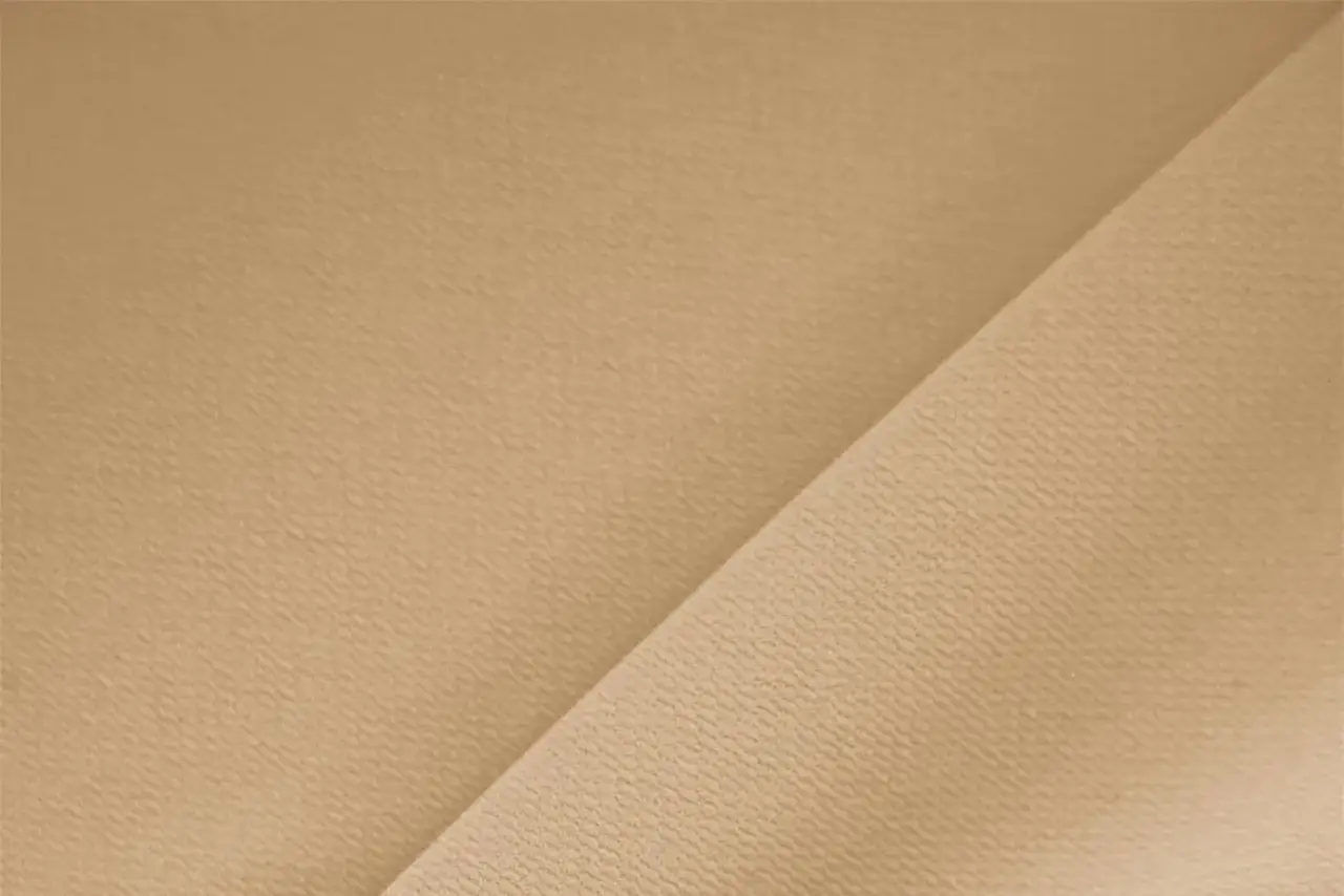 Tessuto in crepe color sabbia, ideale per abiti estivi o invernali, con una texture leggermente granulosa che cattura la luce.