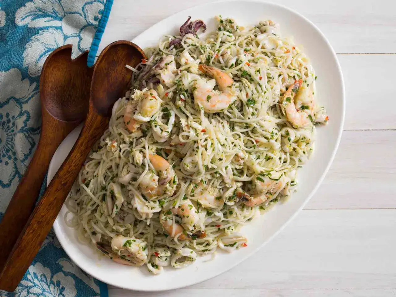 Ein Teller mit köstlicher Pasta mit Fisch, Garnelen und Tintenfischringen, garniert mit frischer Petersilie. Ein wahrhaft italienischer Genuss!