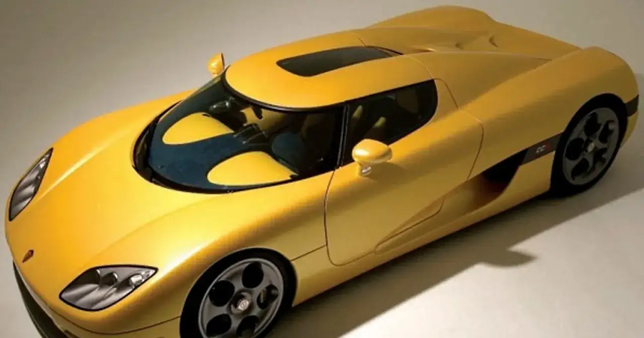 Żółty Koenigsegg CCXR, gdzie błotnik w samochodzie płynnie przechodzi w drzwi, prezentuje swoje sportowe linie.