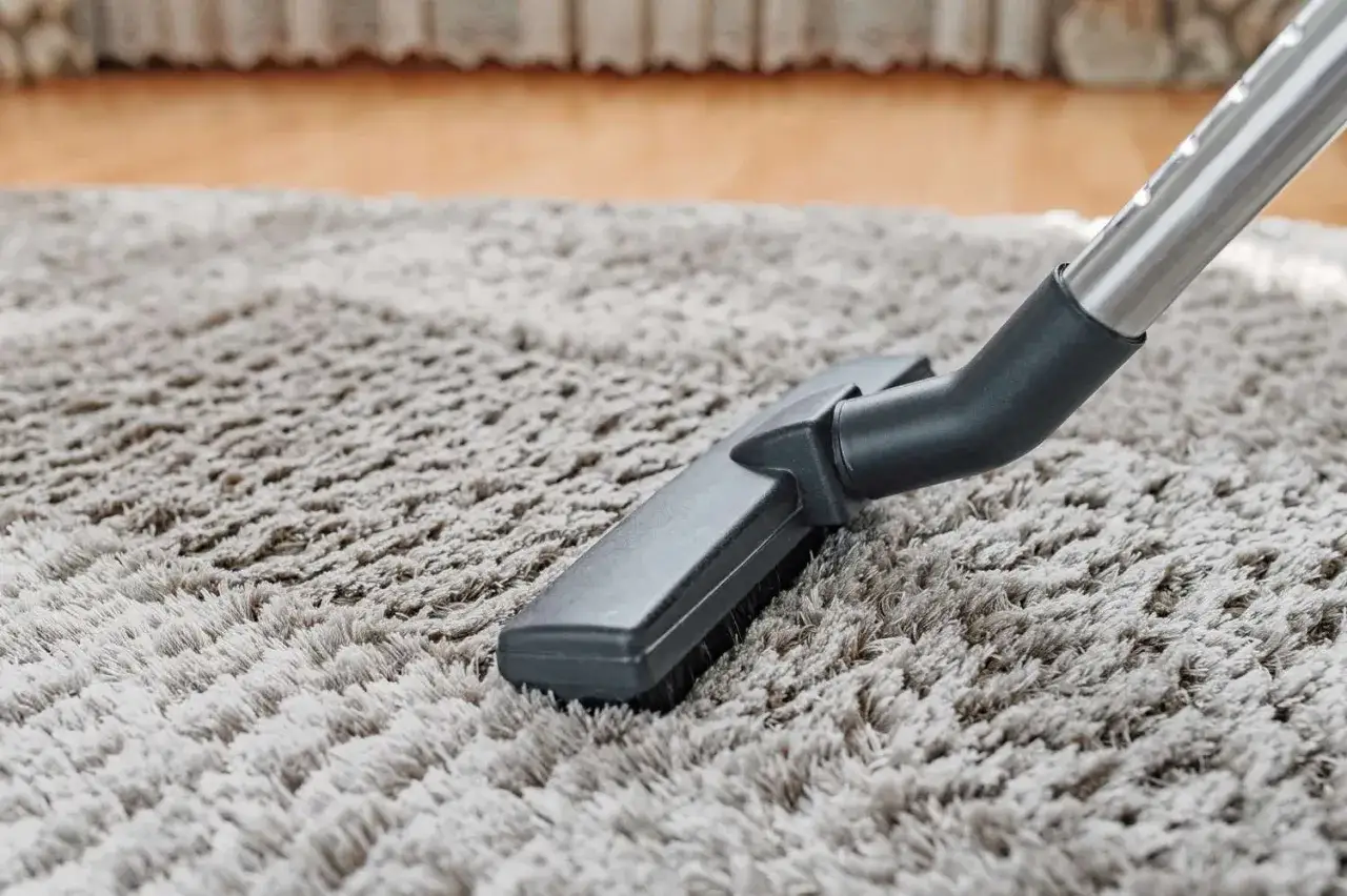Dammsugarmunstycke p&aring; en fluffig matta, redo att fixa nedtrampad matta och ge den nytt liv.