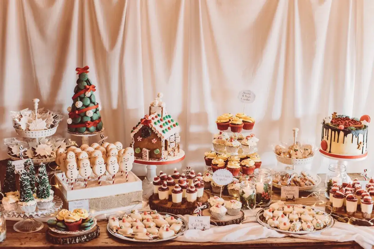Mesa dulce con ideas chuches navidad: casa de jengibre, árbol de macarons, muñecos de nieve, cupcakes y galletas.
