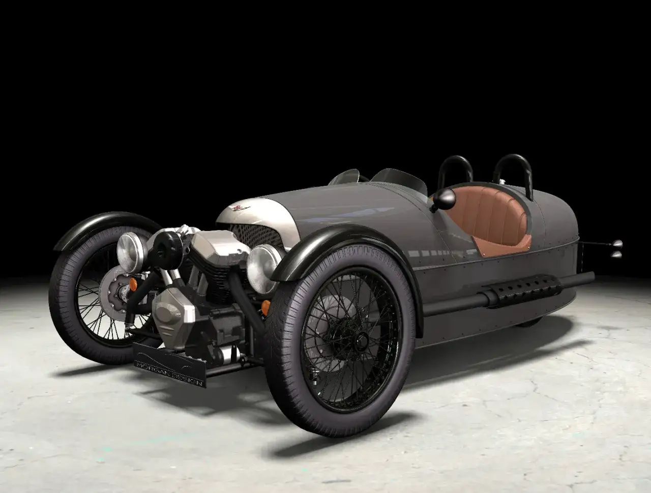 En grå, trehjulig Morgan med brun lädersits. En klassisk reliant bil som väcker nostalgi.