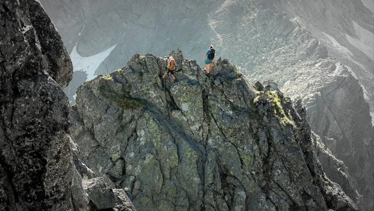 Dw&oacute;ch alpinist&oacute;w pokonuje skalisty grzbiet, zbliżając się do szczytu Gerlach. Droga Martina jest wymagająca, ale widoki wynagradzają trud.