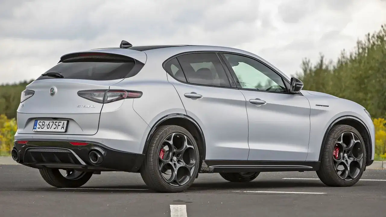 Srebrne Alfa Romeo Stelvio z czarnymi felgami i czerwonymi zaciskami hamulcowymi. Sprawdź aktualną alfa romeo stelvio cena.