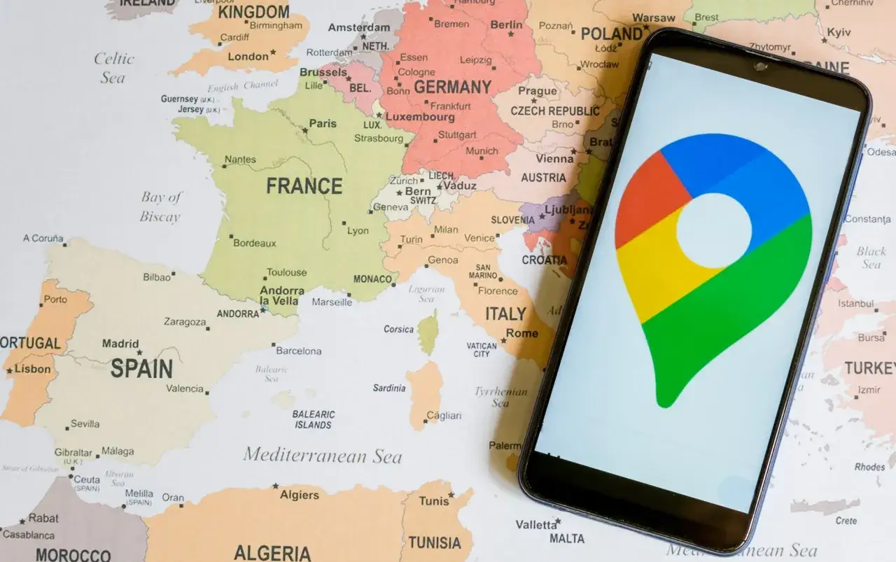 Telefon z ikoną lokalizacji na mapie Europy. Aplikacja nawigacyjna pomaga w ustaleniu lokalizacji telefonu.