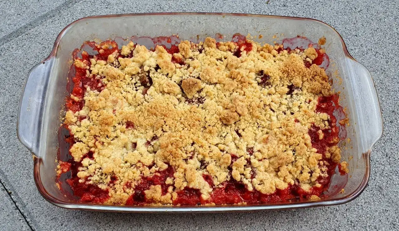 Un délicieux crumble rhubarbe aux morceaux croustillants et à la garniture fruitée, prêt à être dégusté.