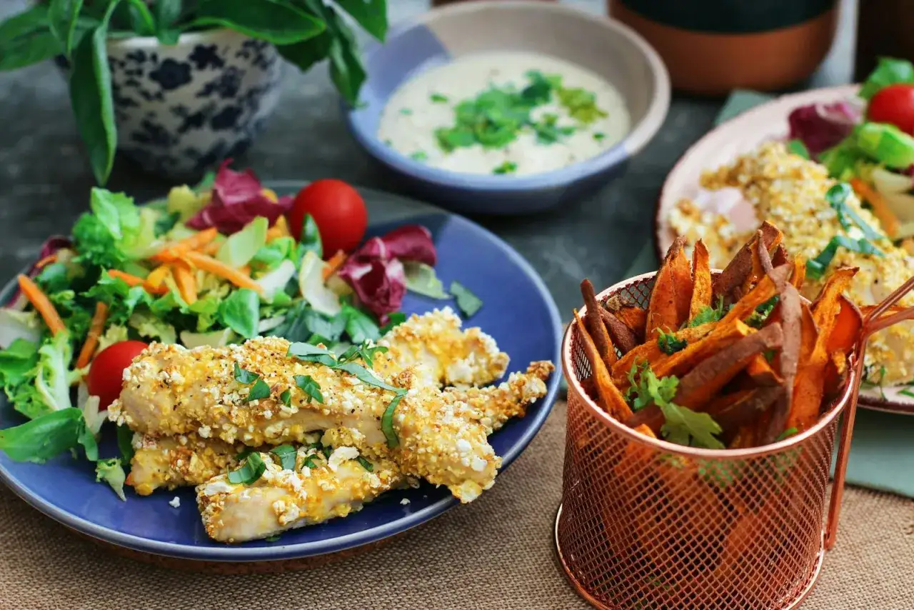 Poulet pané croustillant, frites de patate douce et salade fraîche. Une option sans seigle gluten pour un repas savoureux.