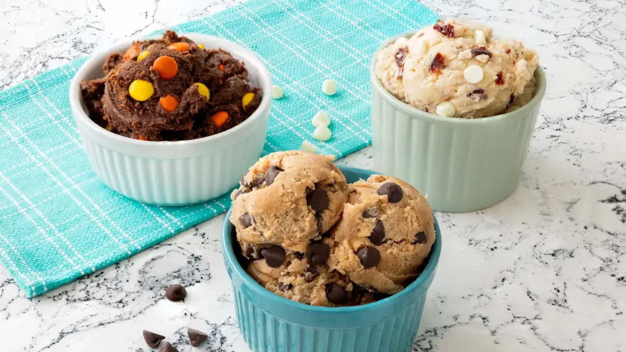 Drei Schalen mit köstlichem Cookie Teig: Schoko-Erdnussbutter, klassischer Chocolate Chip und heller Teig mit Cranberries und weißen Schokostückchen.