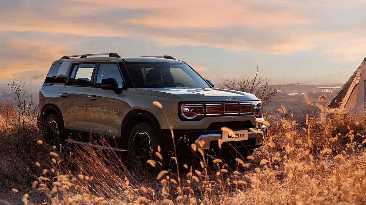 Nowy SUV z napędem na 4 koła, gotowy na przygodę wśród traw i zachodzącego słońca.