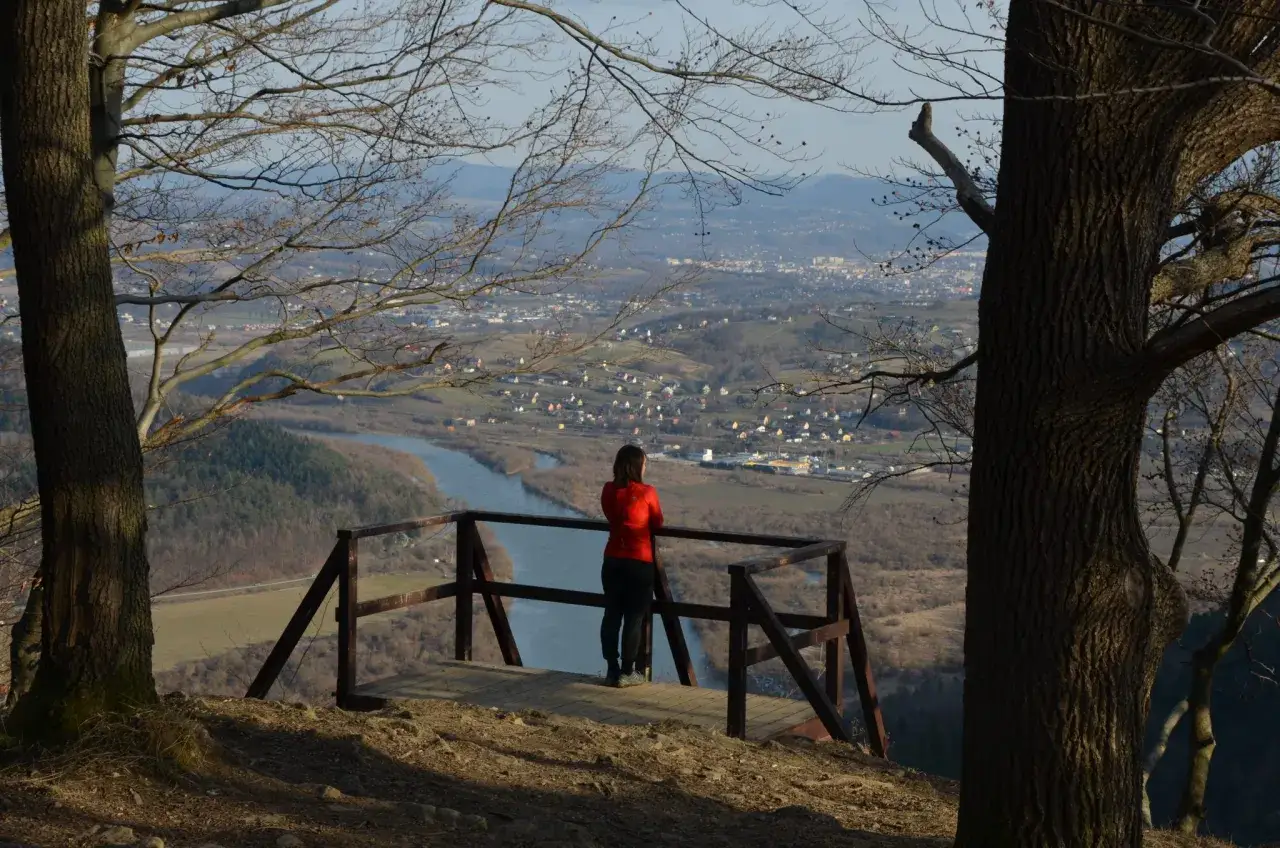 Widok z białowodzkiej góry na dolinę z rzeką i miasteczkiem. Kobieta podziwia panoramę.