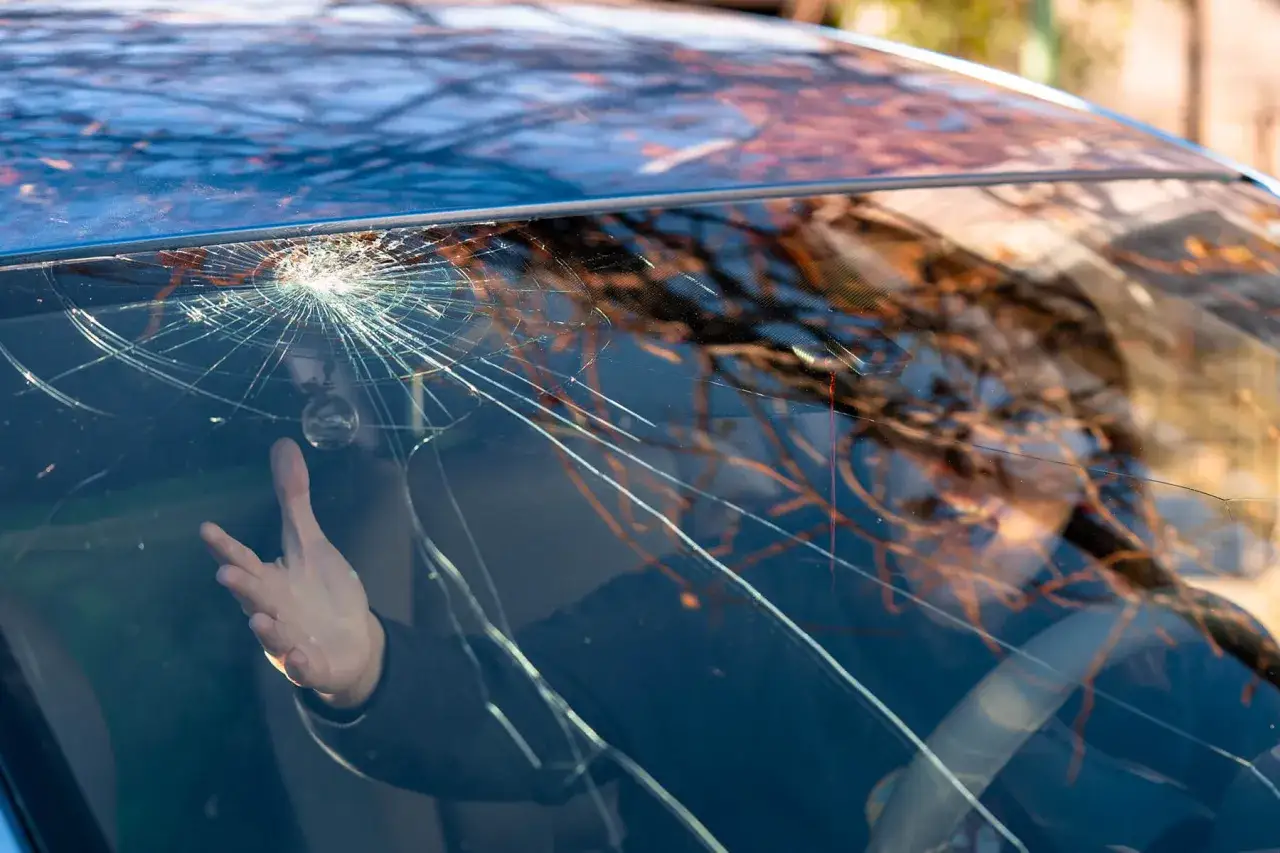 Pare-brise fissuré, un conducteur désespéré face au bris de glace malus.