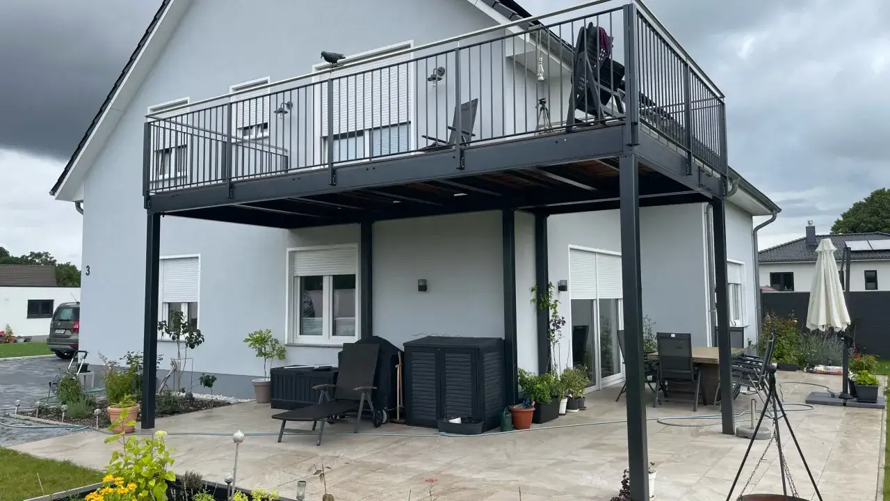 Nowoczesny balkon przyczepny nad tarasem. Zastanawiasz się, ile kosztuje balkon przyczepny? Ten przykład pokazuje jego funkcjonalność.