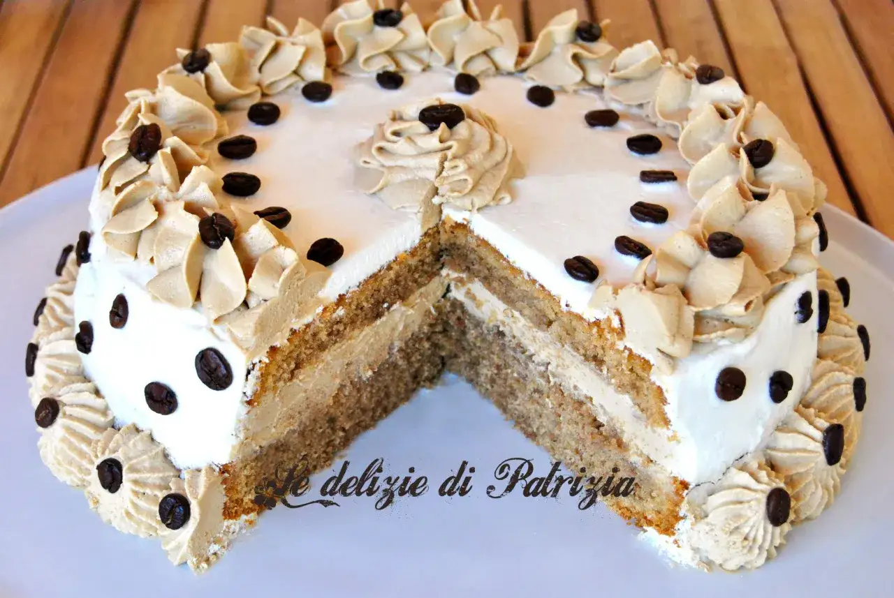 Torta a fette con ganache al caffè espresso, decorata con chicchi di caffè e panna montata.