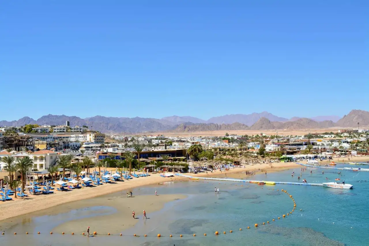Widok na plażę i morze z hotelami w Sharm Grand Plaza Resort. W tle g&oacute;ry.