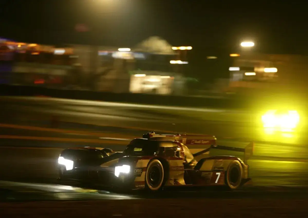 Un coche de Audi Sport compite en las 24 horas de Le Mans, iluminando la noche con sus potentes faros.