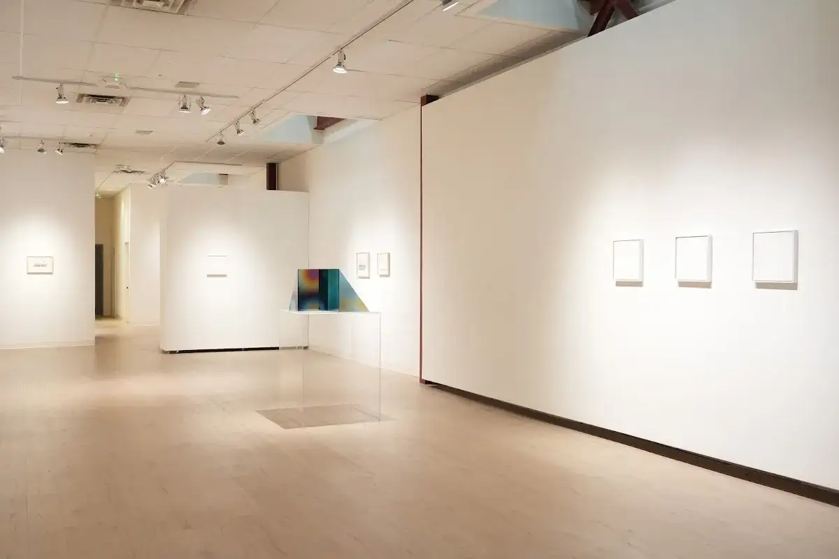 Inside the Richard Levy Gallery, minimalist artworks are displayed on white walls with polished wooden floors.