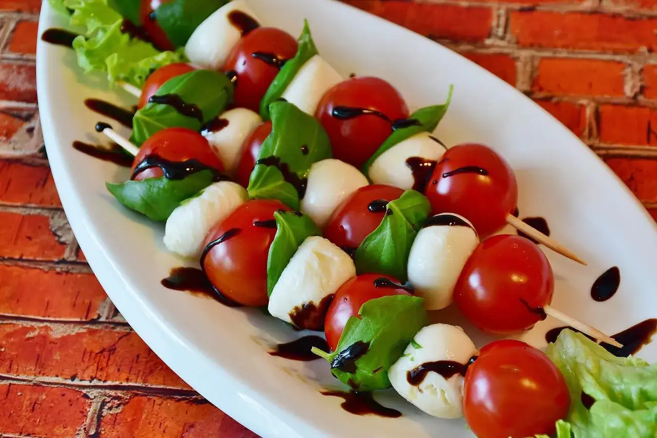 Szukasz pomysłu, co ugotować na kolację? Te szaszłyki caprese z pomidorkami, mozzarellą i bazylią, polane sosem balsamicznym, to idealna inspiracja!