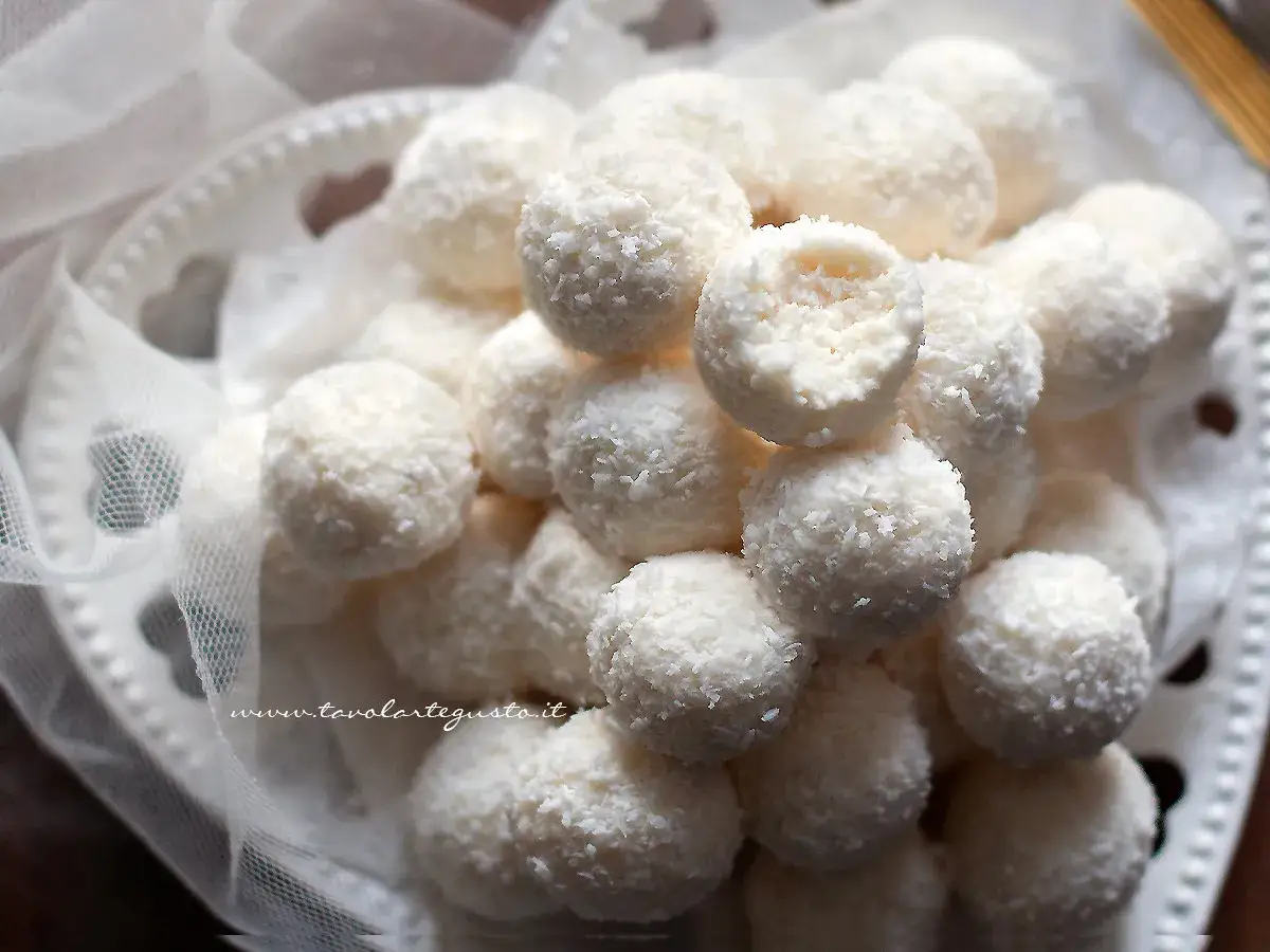 Dolci palline di cocco, morbide e profumate, adagiate su un piatto bianco decorato. Un invito goloso da gustare.