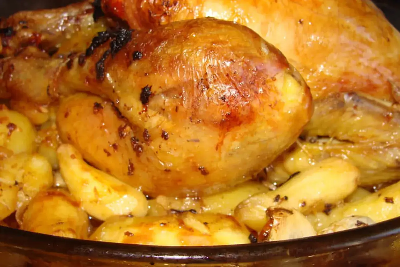 Un plat de poulet au four avec des pommes de terre dorées et juteuses, le tout baignant dans une sauce savoureuse.