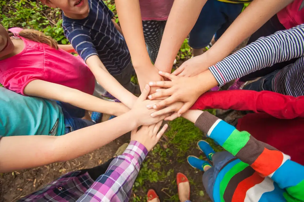 Manos de ni&ntilde;os unidas, un s&iacute;mbolo de **bonitas frases de igualdad cortas para ni&ntilde;os**. Todos somos diferentes, pero juntos somos m&aacute;s fuertes.