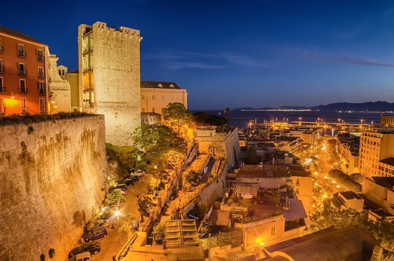 Torre di San Pancrazio e il quartiere Castello illuminati di notte, un'ottima vista per capire cosa vedere a Cagliari in un giorno.